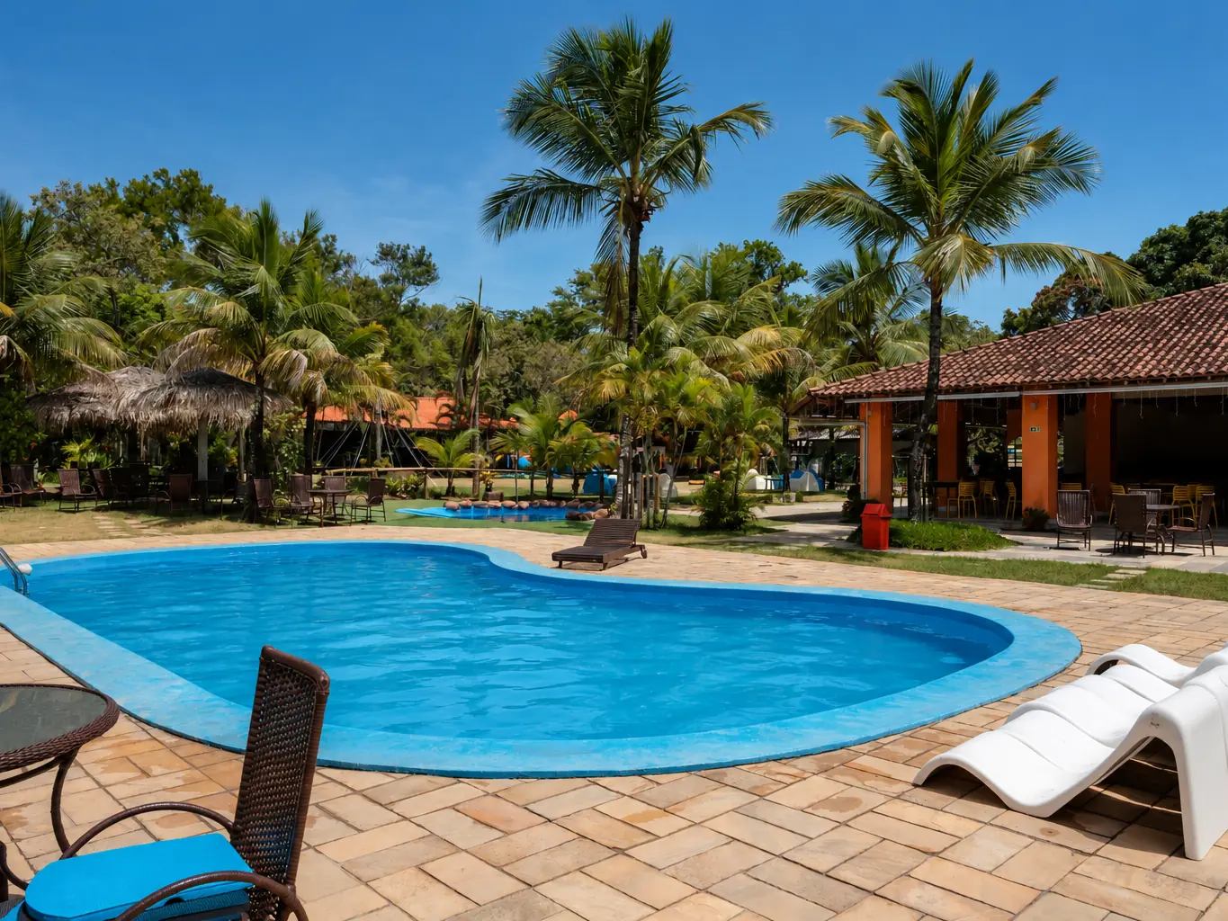 Piscina adulto do Acquamarine Park Hotel com espreguiçadeiras e coqueiros